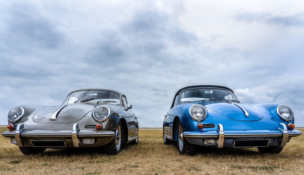 Closeup shot of grey and blue cars put next to each other under a cloudy sky